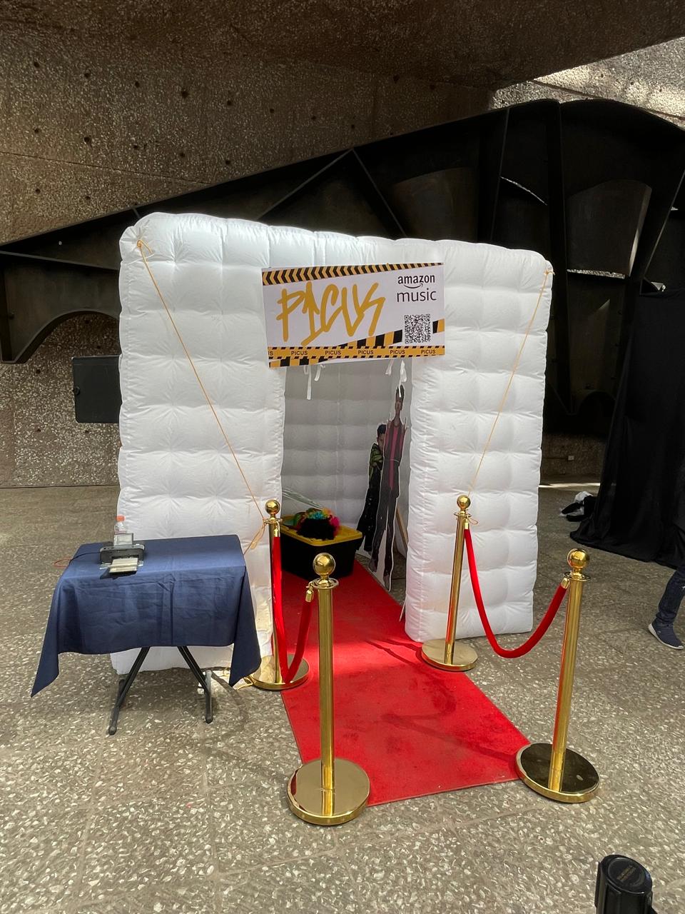 Invitados divirtiéndose con props en la cabina inflable